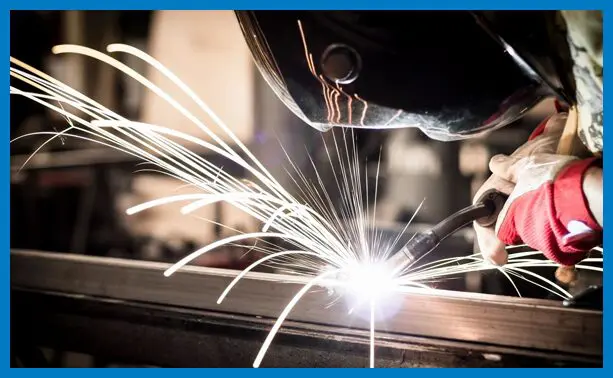 A person welding with sparks flying from the side.